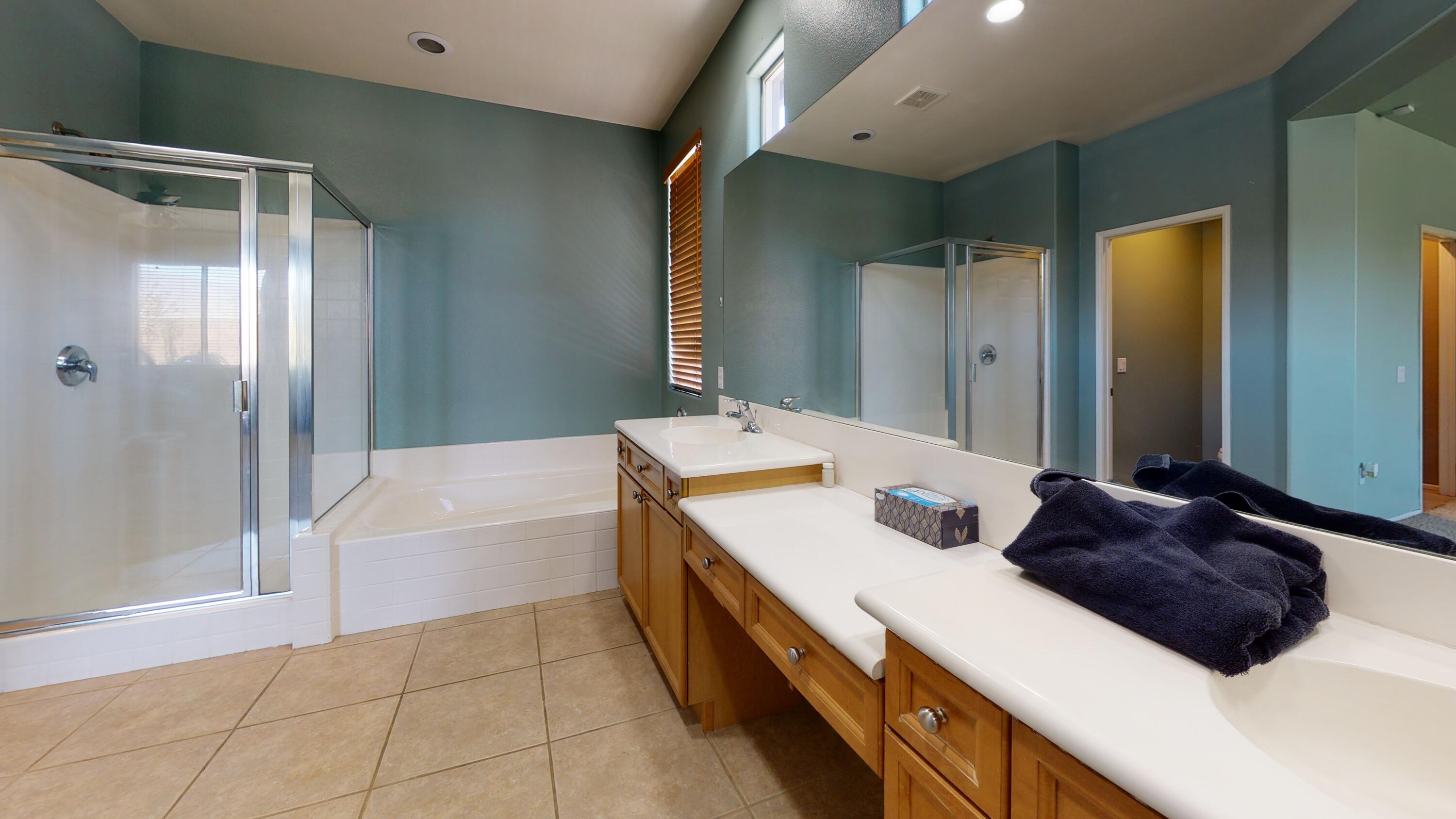 82712 Kyle Drive Indio, CA 92203 - Photo 13 of 29 a bathroom with a double vanity sink a mirror and a bathtub