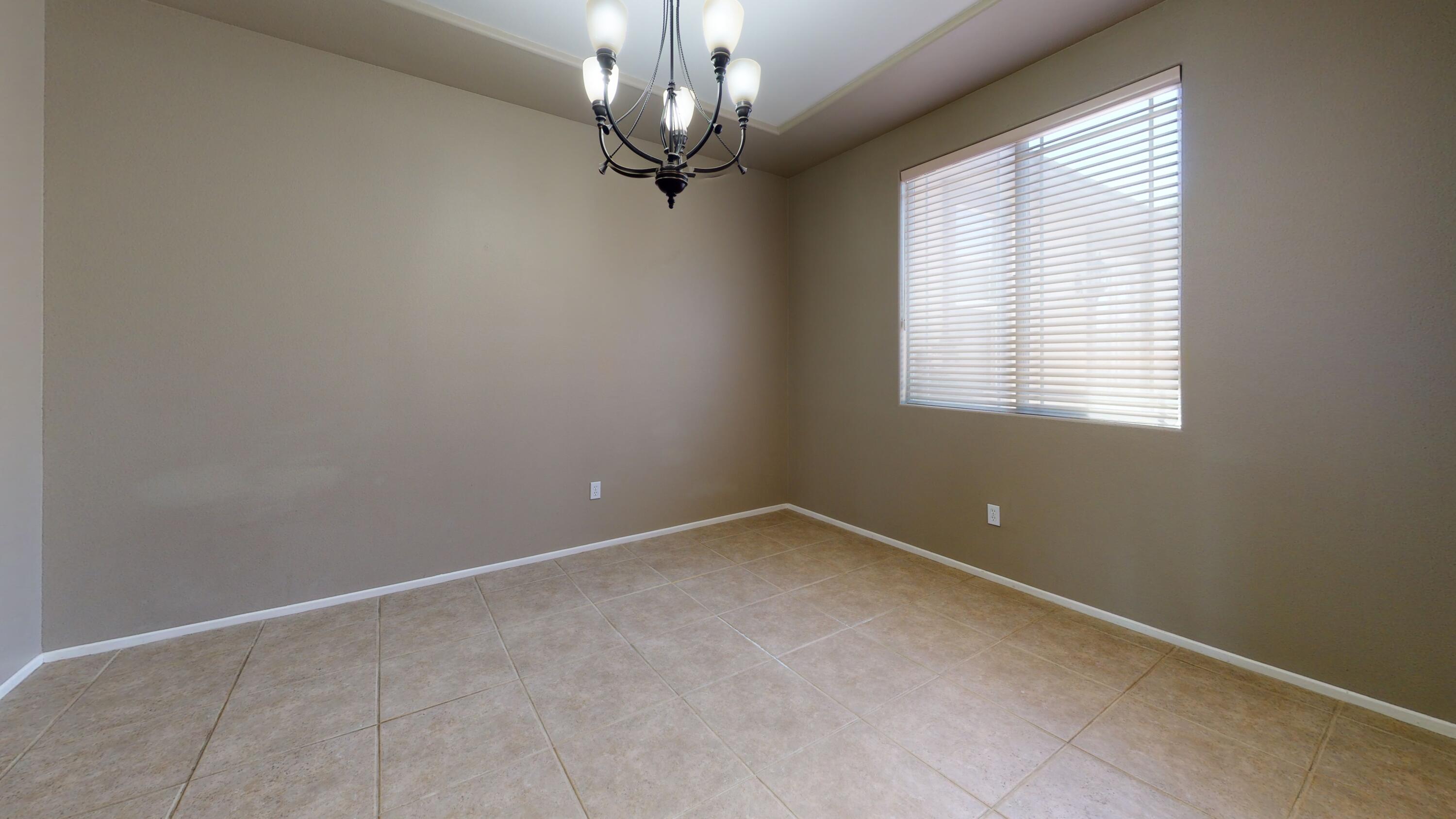 82712 Kyle Drive Indio, CA 92203 - Photo 6 of 29 an empty room with windows and chandelier