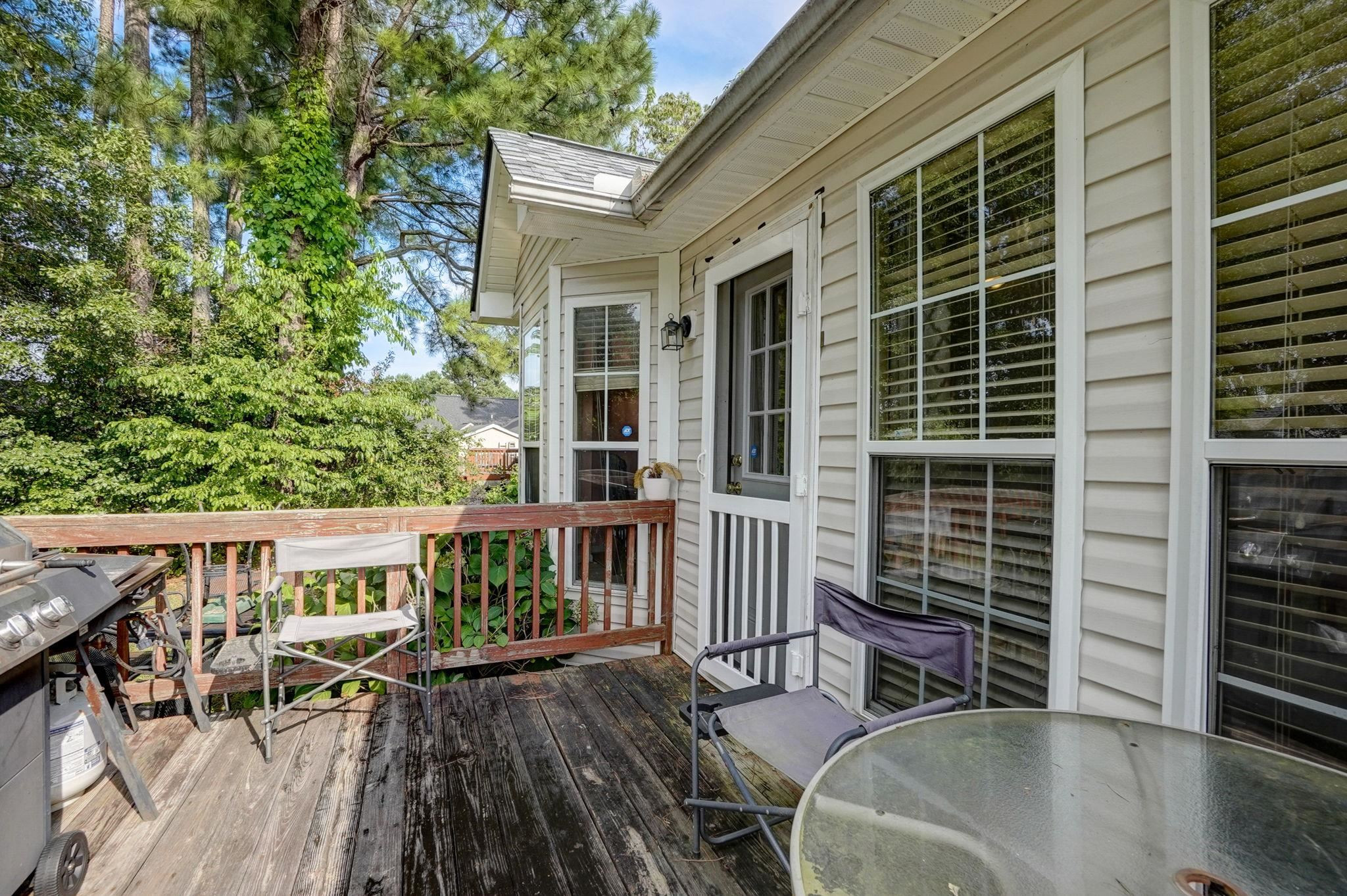 7133 Spanglers Spring Way Raleigh, NC 27610 - Photo 15 of 17 a view of a patio with table and chairs with wooden floor and fence