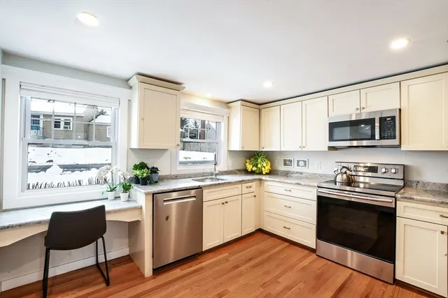a kitchen with stainless steel appliances a white stove top oven and white cabinets