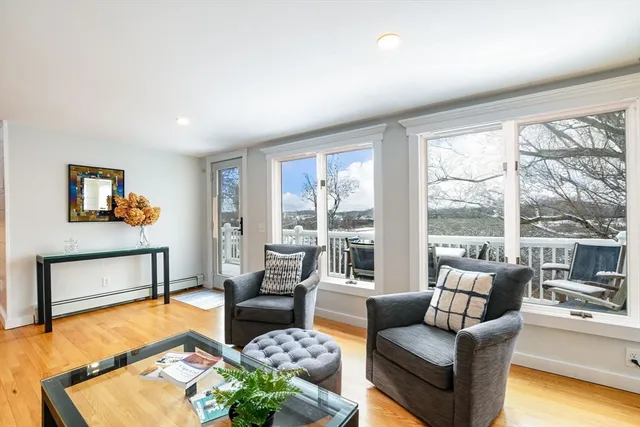 a living room with furniture and a floor to ceiling window next to a large window