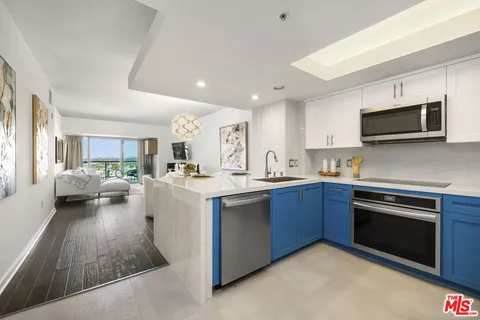 a kitchen with sink a microwave and cabinets