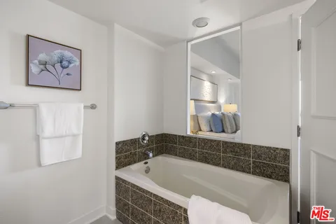 a bathroom with a granite countertop sink a mirror and a shower