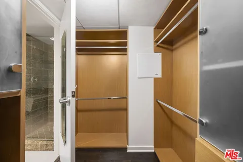 a view of walk in closet with wooden floor