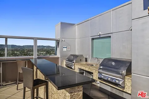 a view of a patio with couches table and chairs under an umbrella
