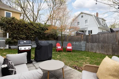 a view of a backyard with furniture and a fire pit