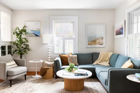 a living room with furniture a window and a potted plant