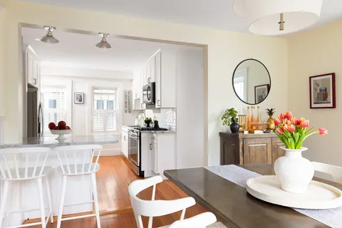 a living room with furniture flowerpot and a chandelier