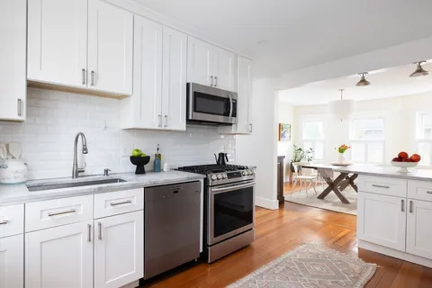 a kitchen with white cabinets and stainless steel appliances