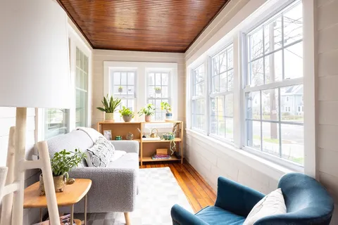 a living room with furniture and floor to ceiling windows