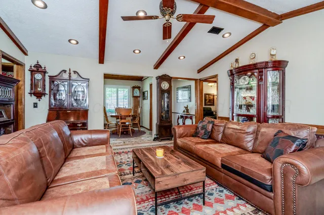 a living room with furniture a ceiling fan and a rug
