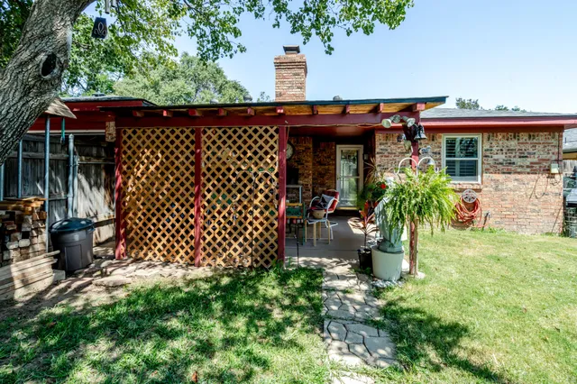 a view of a backyard with table and chairs and potted plants