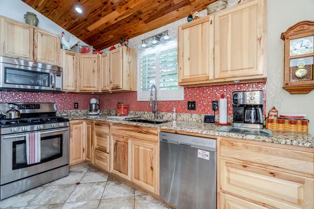 a kitchen with stainless steel appliances granite countertop a sink and cabinets