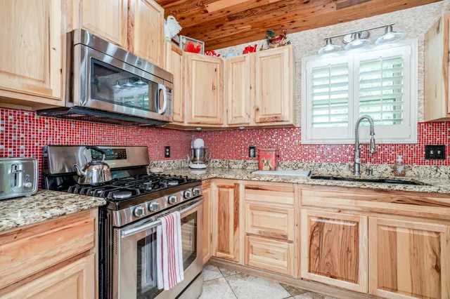 a kitchen with granite countertop a stove sink and cabinets