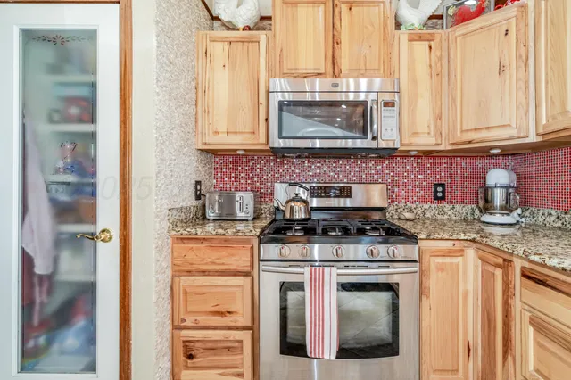 a kitchen with stainless steel appliances granite countertop a stove and a microwave