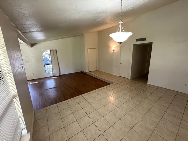 a view of an empty room with a fireplace and a window