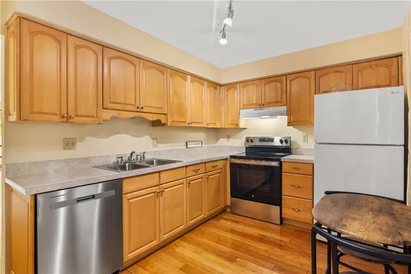a kitchen with stainless steel appliances granite countertop a stove a sink and a refrigerator