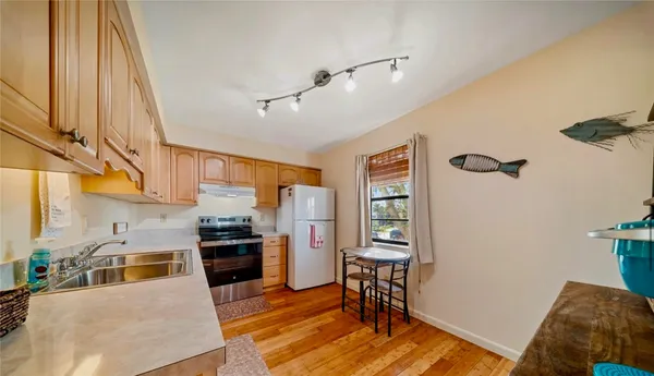 a kitchen with stainless steel appliances granite countertop a refrigerator a stove and a sink with cabinets