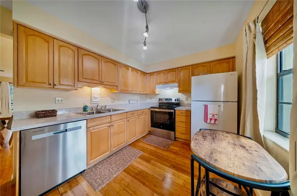 a kitchen with granite countertop a sink stainless steel appliances and cabinets