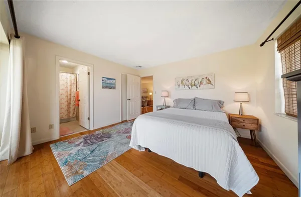 a bedroom with a large bed and wooden floor