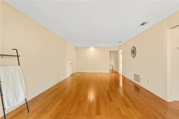 a view of empty room with wooden floor