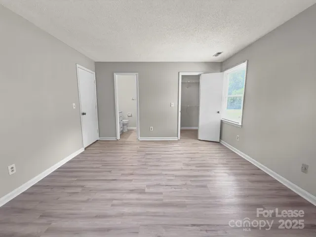 a bathroom with a toilet a sink and wooden floor