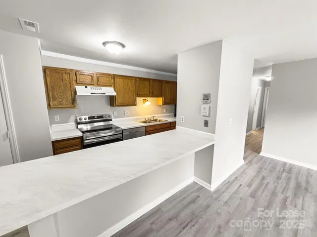 a large white kitchen with a refrigerator a stove a microwave and cabinets