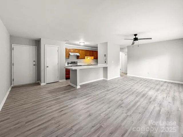 a kitchen with a sink dishwasher and cabinets with wooden floor