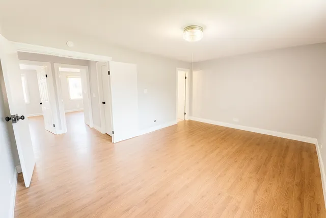 a view of a livingroom with wooden floor and a ceiling fan
