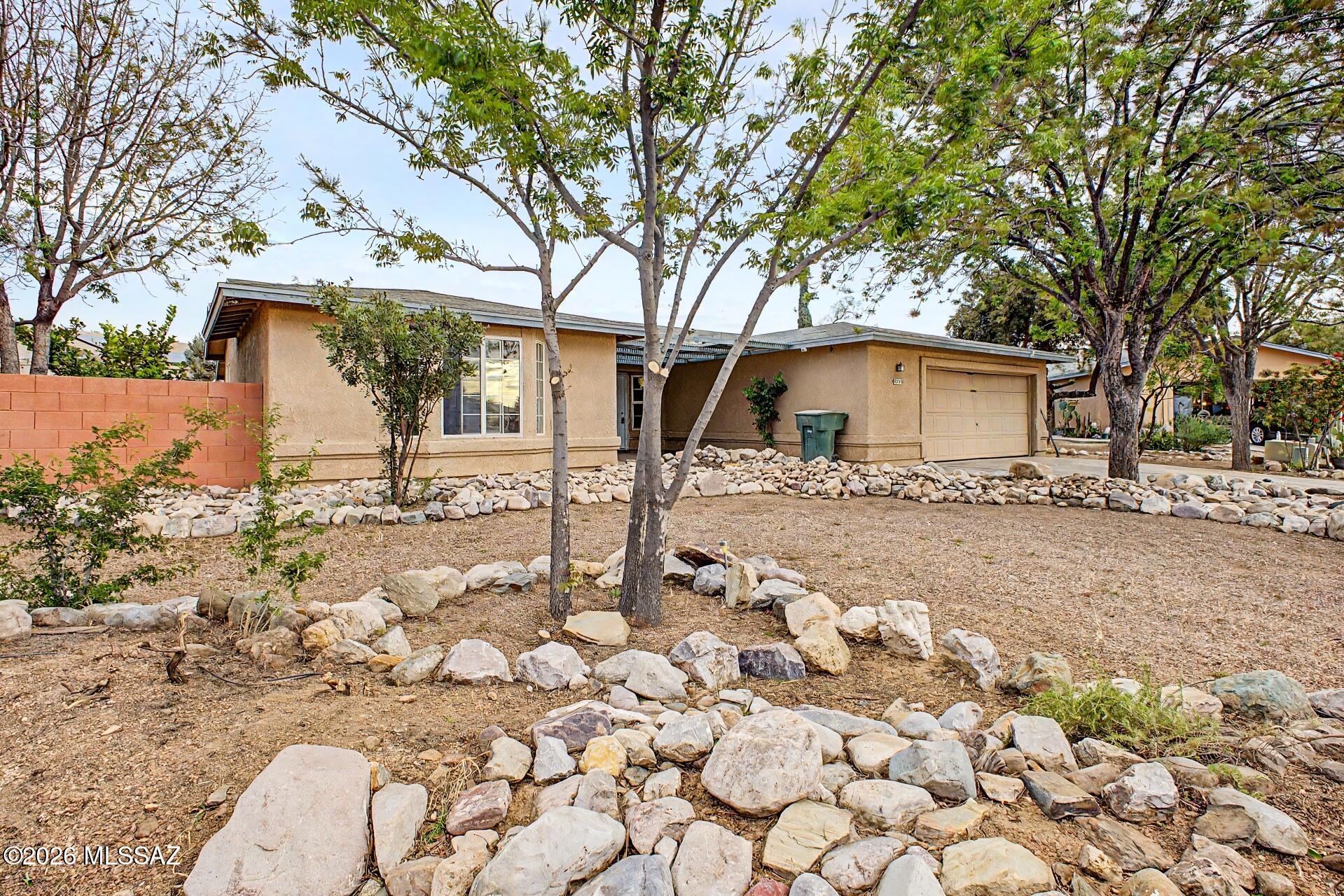 9810 East Stonehaven Way Tucson, AZ 85747 - Photo 4 of 27 a white house that has tree in front of it