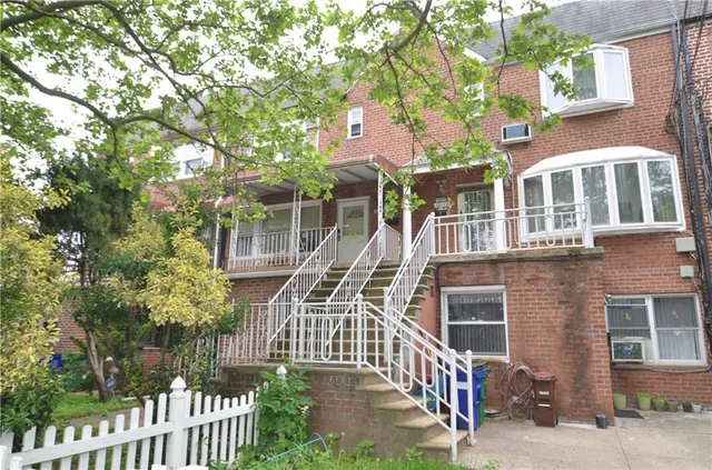 a front view of a house with a tree
