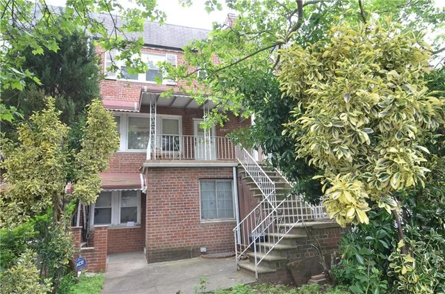 a front view of a house with a tree