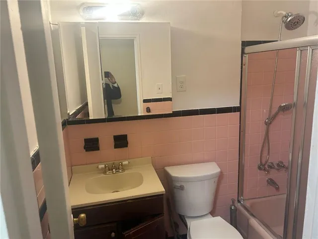 a bathroom with a sink a toilet a mirror and shower