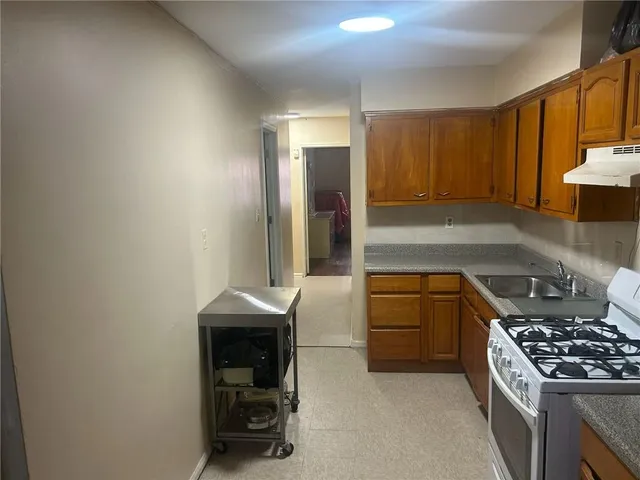 a kitchen with granite countertop a sink stove and cabinets