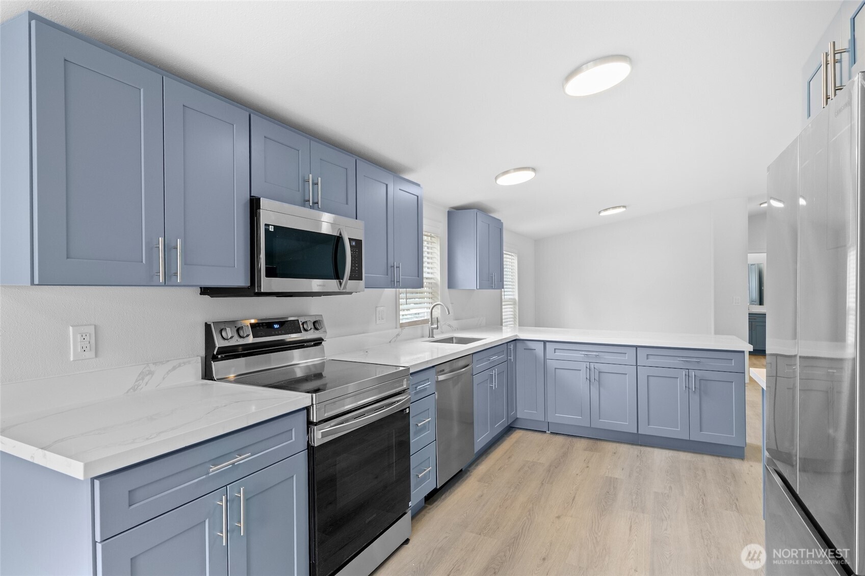 10324 Delphi Road Southwest, Unit 14 Olympia, WA 98512 - Photo 9 of 25 a kitchen with stainless steel appliances granite countertop a sink and dishwasher a stove top oven with wooden floor