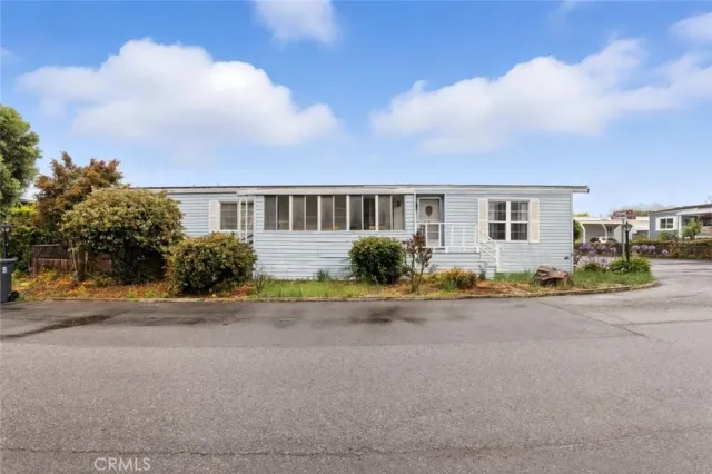 a kitchen with stainless steel appliances a refrigerator a stove a sink and white cabinets with wooden floor