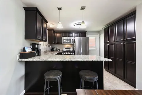 a kitchen with stainless steel appliances granite countertop a sink a stove and a refrigerator