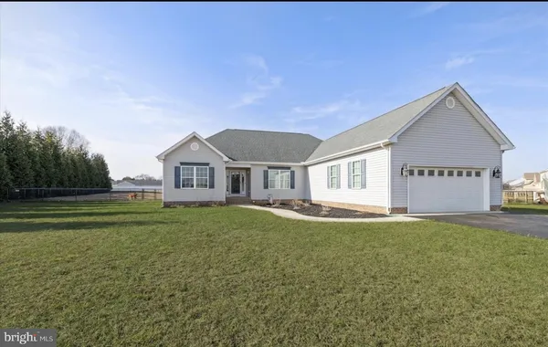 a view of a house with a big yard and large tree
