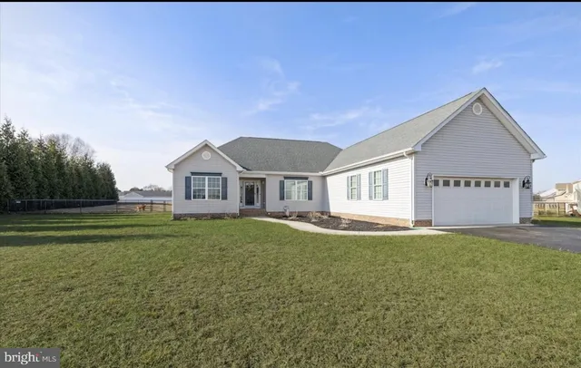 a view of a house with a big yard and large tree