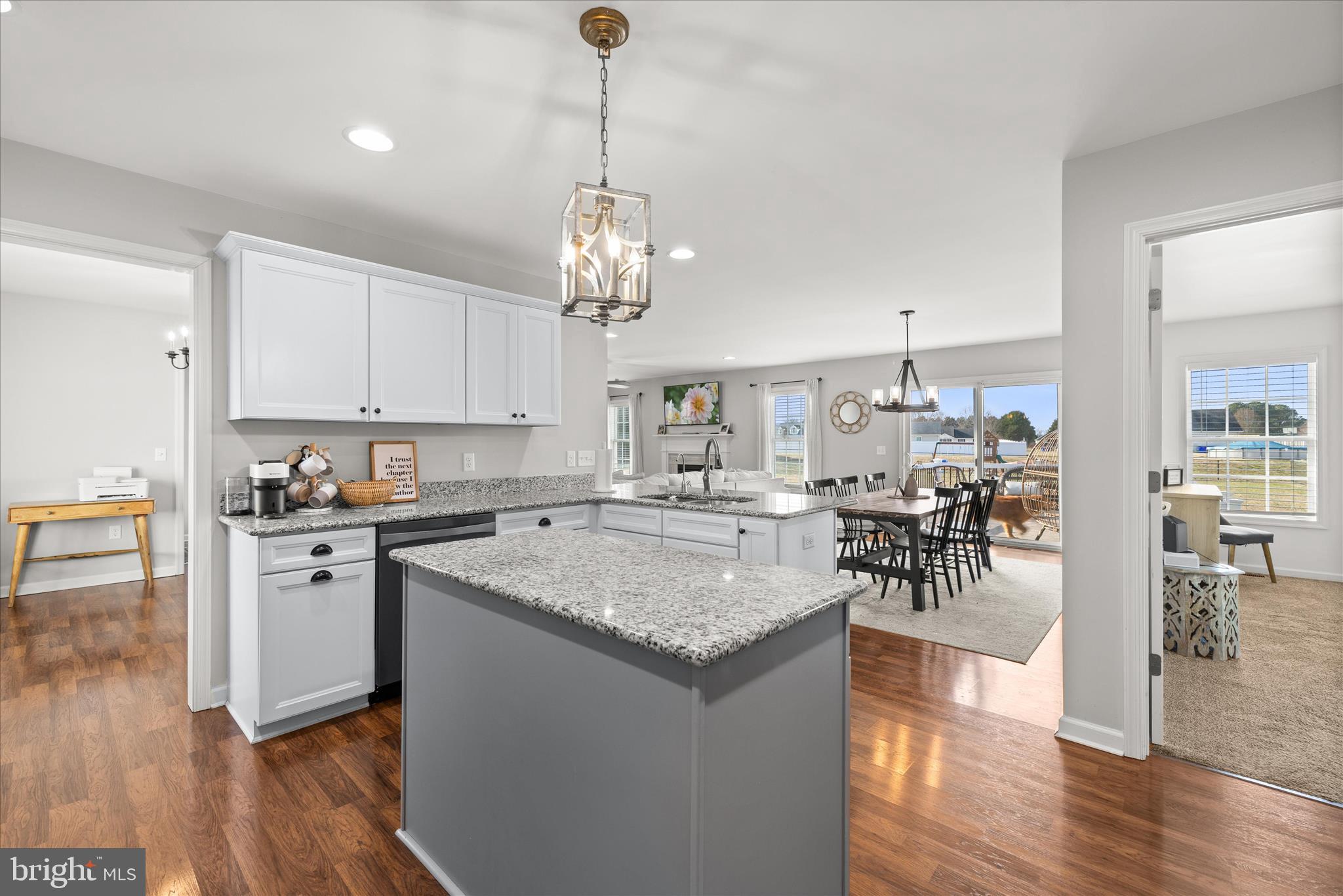 36831 Red Berry Road Delmar, DE 19940 - Photo 17 of 46 a open kitchen with stainless steel appliances granite countertop a stove oven a sink dishwasher and a dining table with wooden floor