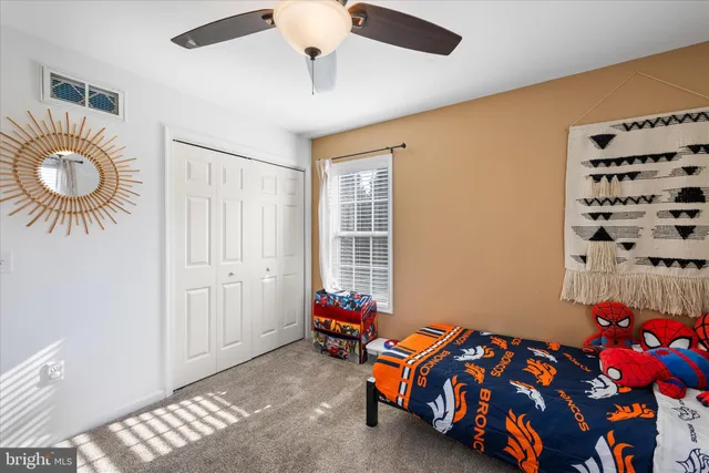 a spacious bedroom with a bed a dresser and a window