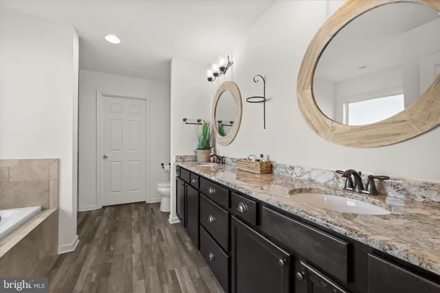 a bathroom with a tub sink and mirror