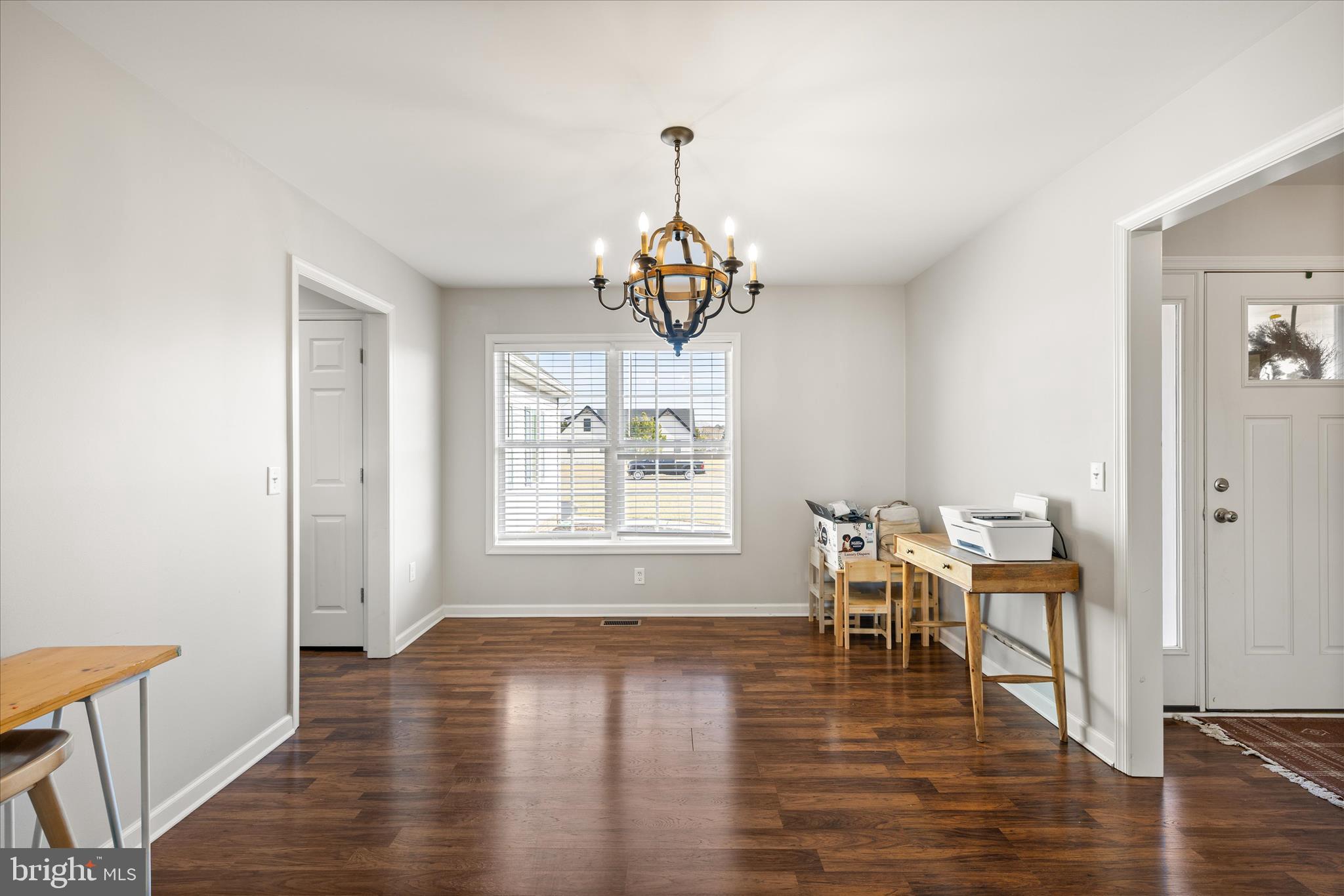 36831 Red Berry Road Delmar, DE 19940 - Photo 6 of 46 a dining room with wooden floor a chandelier a wooden table and chairs