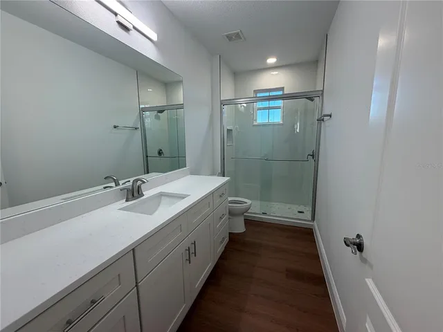 a bathroom with a double vanity sink and mirror with shower