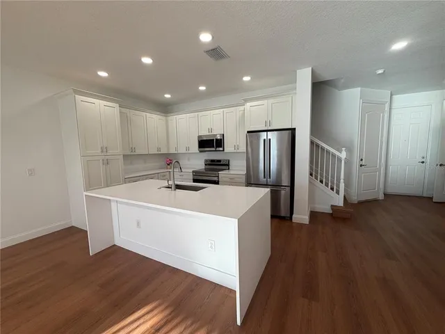 a kitchen with stainless steel appliances a refrigerator and a stove top oven