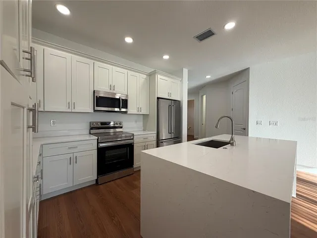 a kitchen with stainless steel appliances a stove sink and microwave