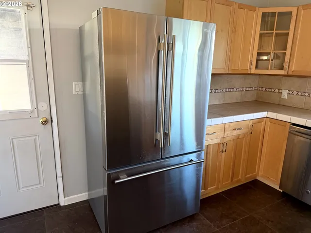 a kitchen with metallic refrigerator and sink