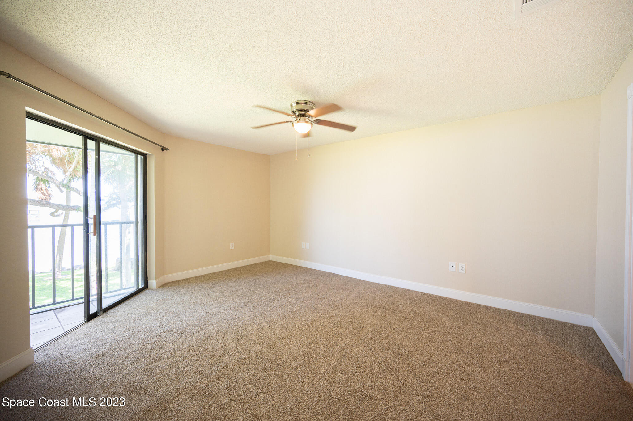 100 Canebreakers Drive, Unit 206 Cocoa, FL 32927 - Photo 13 of 36 an empty room with a window and a ceiling fan