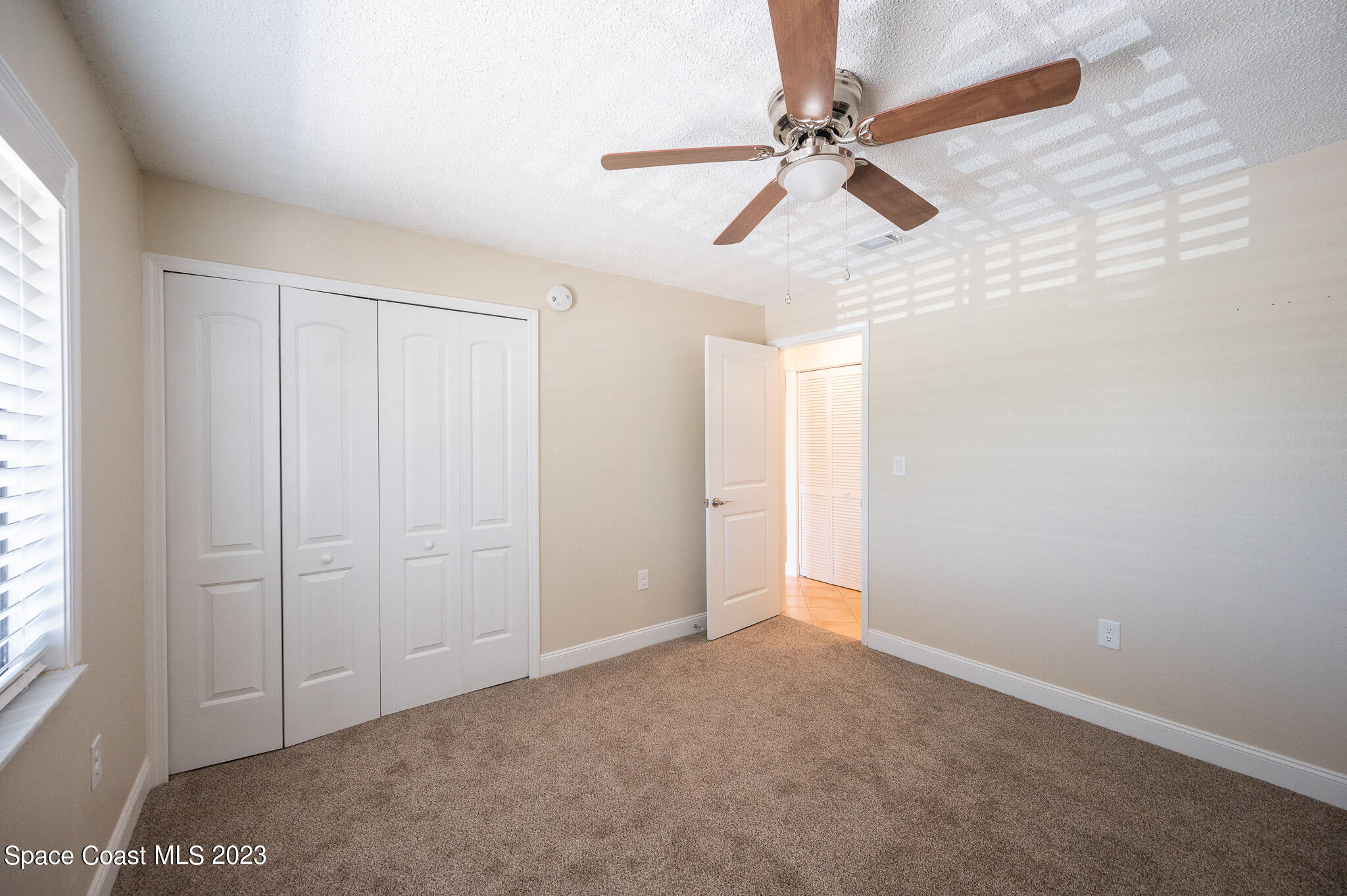100 Canebreakers Drive, Unit 206 Cocoa, FL 32927 - Photo 15 of 36 an empty room with windows and fan