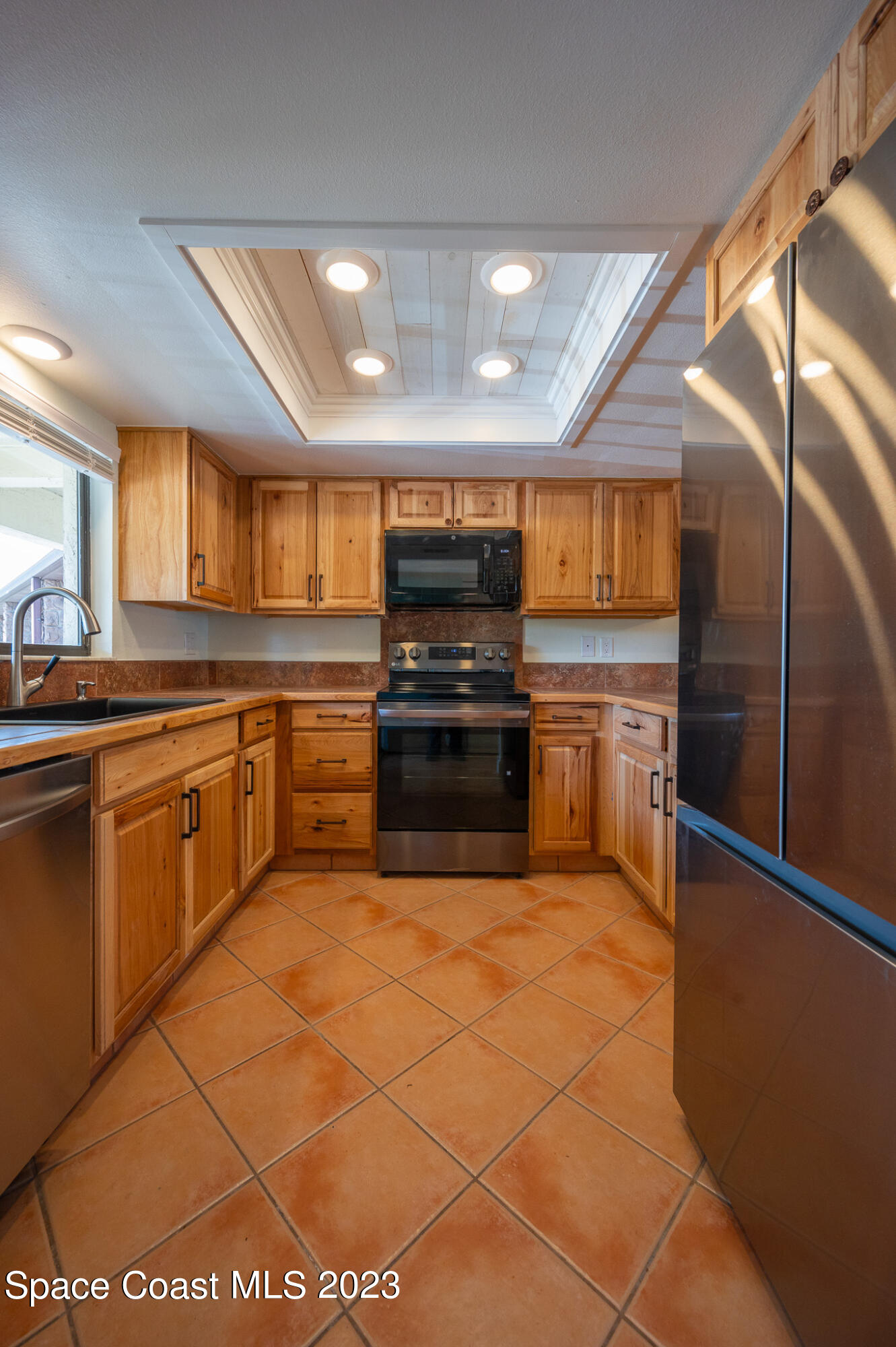 100 Canebreakers Drive, Unit 206 Cocoa, FL 32927 - Photo 10 of 36 a kitchen with stainless steel appliances granite countertop a stove a sink and a refrigerator